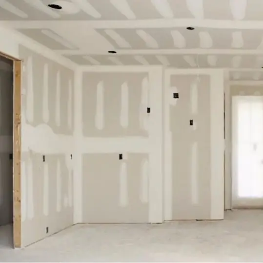 Ambiente con paredes de drywall y juntas masilladas listas para empastar